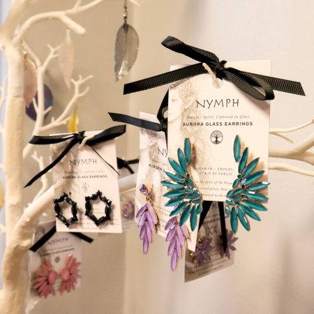 Glazen oorbellen uit de Nymph Collectie in verschillende kleuren en vormen, elegant gepresenteerd met zachte natuurlijke belichting.